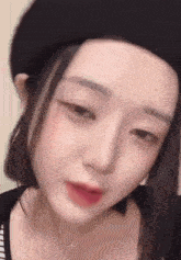 a close up of a woman 's face wearing a beret and a necklace .