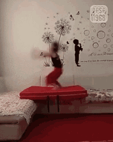 a person jumping on a red mat in front of a wall that says " all our dream "
