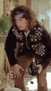 a man with curly hair is holding a camera and looking at something