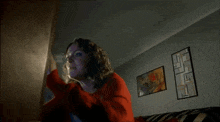a woman in a red sweater is sitting on a black and white couch