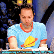 a man in a blue t-shirt is whispering at the same time uk otoa