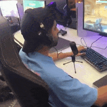 a man wearing headphones and a hat is playing a video game on a computer