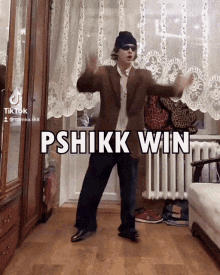 a man in a suit and hat is dancing in a room with the words pshikikk win written on the bottom