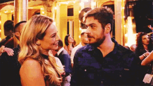 a man and woman are looking at each other in a crowd