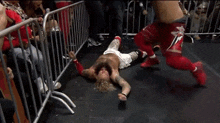 a man without a shirt is standing in front of a crowd in a ring .