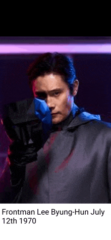 frontman lee byung-hun july 12th 1970 is holding a gun in a dark room .