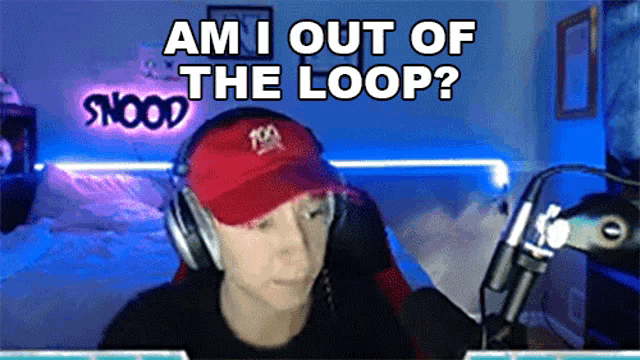 a man wearing headphones and a red hat says 