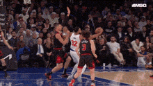 a group of basketball players are playing a game of basketball .