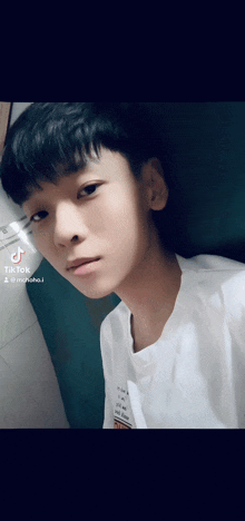 a young man is taking a selfie with a tik tok watermark on his face