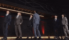 a group of men in suits and ties are dancing