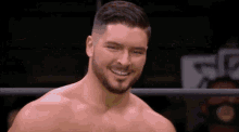 a man with a beard is smiling while standing in a ring .