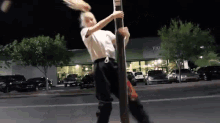 a woman is standing on a pole in front of a building that says 100