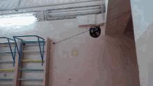 a volleyball is hanging from a string on a wall