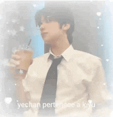a man in a suit and tie is holding a cup of coffee .