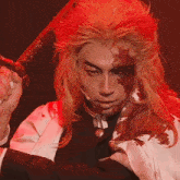 a man with blood on his face holding a sword