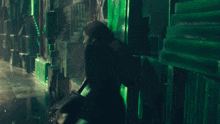 a woman stands in a dark room with green walls