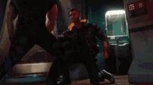 a man in a black leather jacket is fighting another man in a green shirt