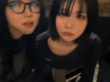 two girls wearing glasses are standing next to each other .