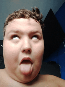 a boy making a funny face with his tongue sticking out