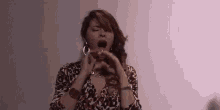 a woman yawning with her mouth open wearing a leopard print dress