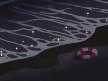 a life preserver sits on the shore of the ocean