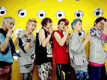 a group of young men standing in front of a yellow wall with circles on it
