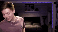 a young man wearing a purple shirt with a patch on the back that says ' a ' on it