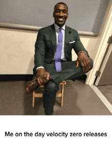 a man in a suit and tie sits on a wooden stool