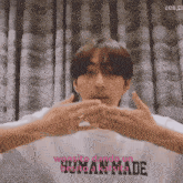 a young man wearing a white shirt that says human made on it