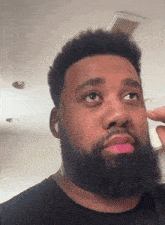 a man with a beard is wearing ear buds and making a funny face