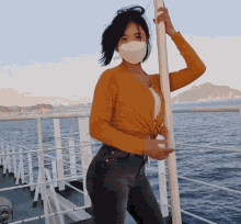 a woman wearing a mask is standing on a boat in the water