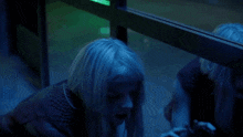 a woman covering her mouth with her hand in front of a green light