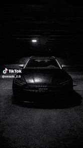 a black audi is parked in a dark garage with tiktok written on the bottom