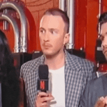 a man is talking into a microphone with the letter n on it .