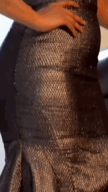 a woman in a silver dress is holding her butt .