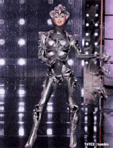 a woman in a futuristic costume is dancing on a stage with tumblr written below her