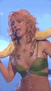 a woman in a green top has a yellow glove on her shoulder