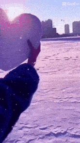 a person holding a heart shaped balloon in the snow with the caption cap cut