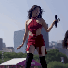 a woman in a red dress is holding a microphone in her hand