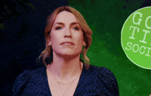 a woman stands in front of a green sign that says " go to social "