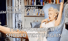 a woman in a white dress is sitting in a chair with her legs crossed and says " don 't rush me "