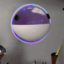 a purple and white ball with a black hole in it