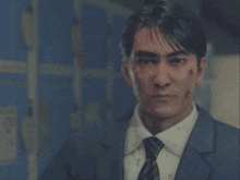 a man in a suit and tie is pointing a gun to his head