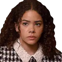 a woman with curly hair wearing a plaid jacket and pearl collar