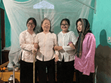 a group of women standing next to each other with one wearing a scarf around her head