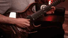 a man is playing an electric guitar with a g on the back