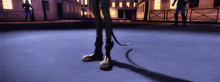a person is standing on a concrete surface with a cat tail .