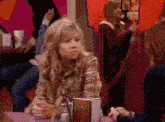 a girl in a plaid shirt sits at a table with a menu on it