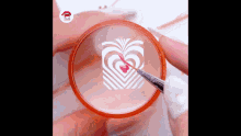 a person is painting a heart on their nails with a brush .