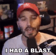 a man in a red hat is talking into a microphone and saying `` i had a blast ''
